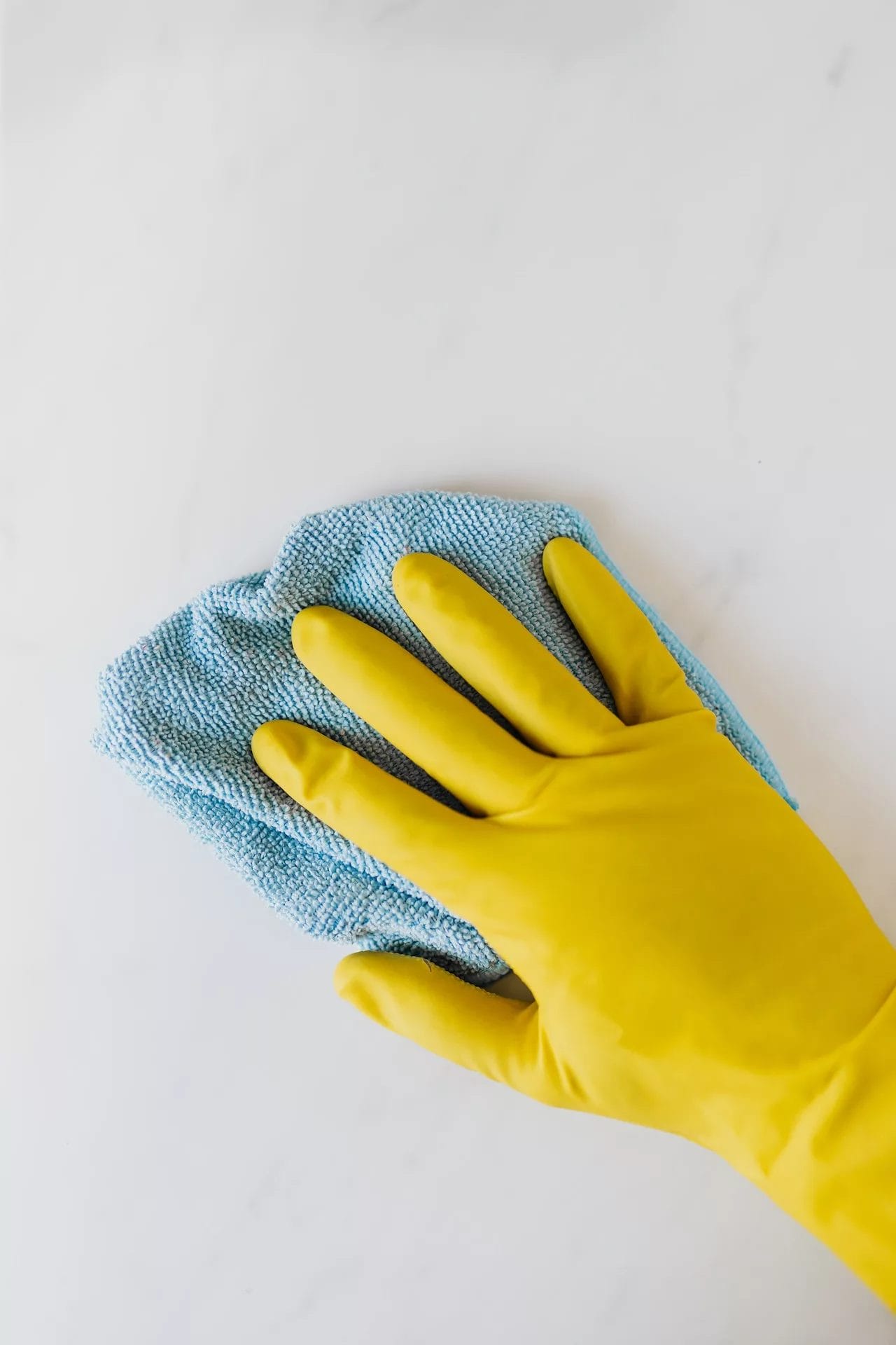Cleaning the counter with piece of clothes and yellow glove