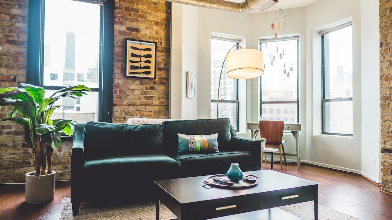 green sofa with big hanging lamp